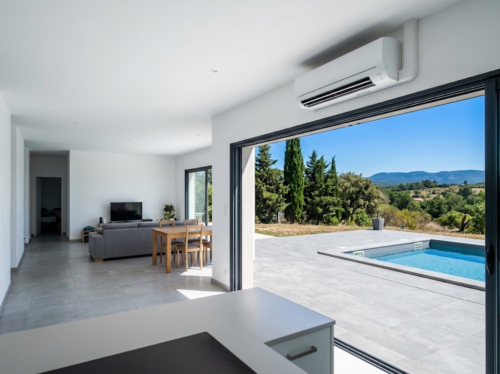 Entreprise de climatisation à Pertuis : séjour d'une villa équipé d'une unité murale, ouvert sur la piscine